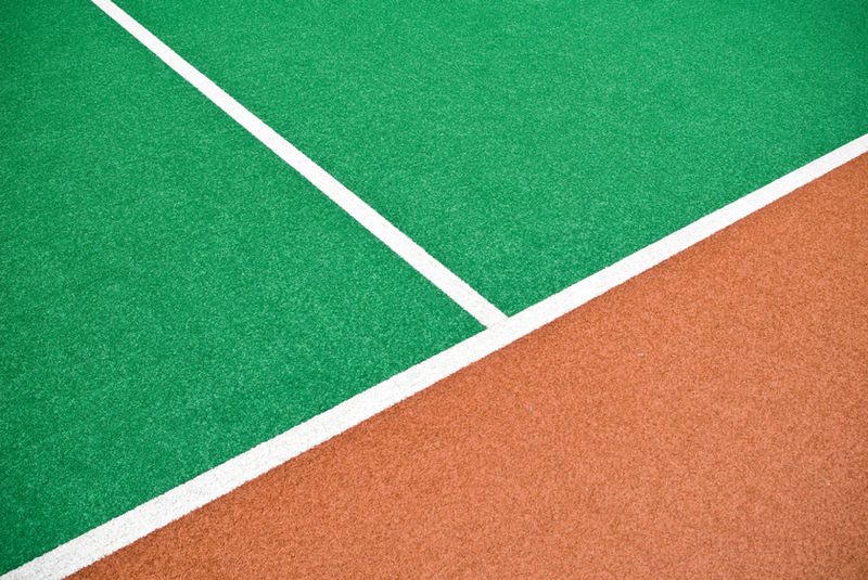 Linee bianche che dividono superfici di gioco verde e terracotta.